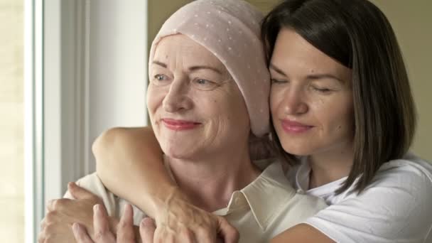 Молодая женщина обнимает свою больную маму после химиотерапии. Любовь, уход и поддержка в семье больного раком. — стоковое видео