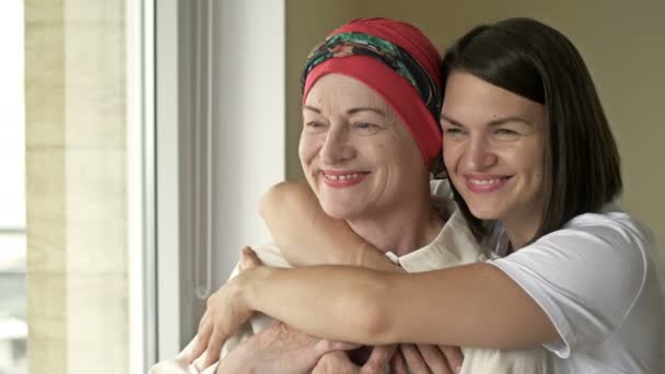 La giovane donna abbraccia la madre malata dopo la chemioterapia. Amore, cura e sostegno nella famiglia di un malato di cancro. — Video Stock