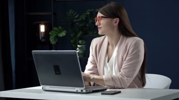 Mulher de negócios bonita distraído de trabalhar em um laptop. Ela sorri sonhadoramente. — Vídeo de Stock