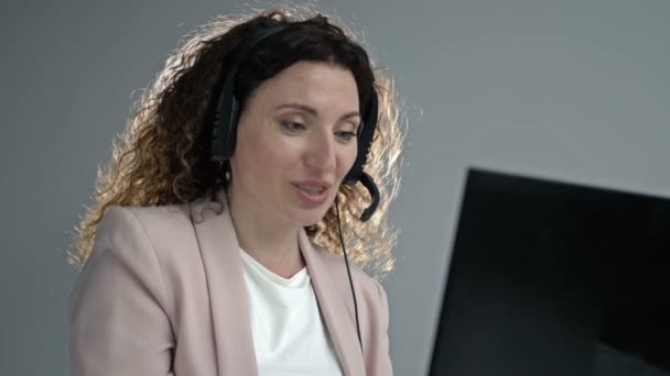 Customer support agent of call center met headset werkt op desktop computer, terwijl de ondersteuning van de klant op telefoongesprek. Vertegenwoordiger van de exploitant van de dienst. — Stockvideo