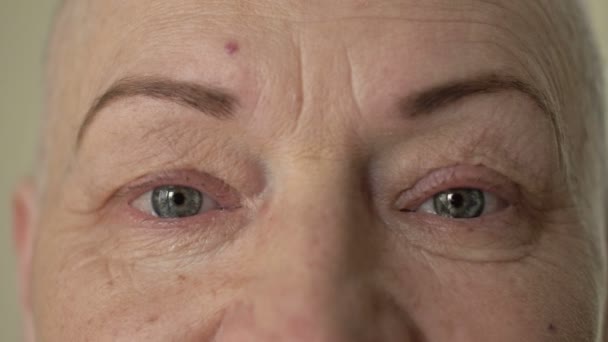 Лицо и глаза 60-летней лысой женщины. Депрессия и стресс, вызванные серьезными заболеваниями или проблемами. Крупный план. Крупный план. — стоковое видео