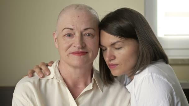 Jonge vrouw knuffelt haar zieke moeder na chemotherapie. Liefde, zorg en ondersteuning in de familie van een kankerpatiënt. — Stockvideo