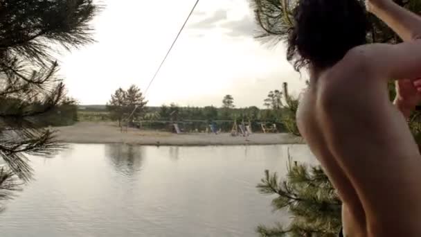 El adolescente se está divirtiendo en el lago. Se pasea por el lago y salta al agua. Deleite y placer de las vacaciones de verano. — Vídeos de Stock