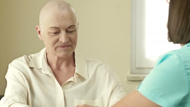 Kanserli yaşlı bir kadın, kemoterapiden sonra kel, bir onkologla görüşüyor.. — Stok video