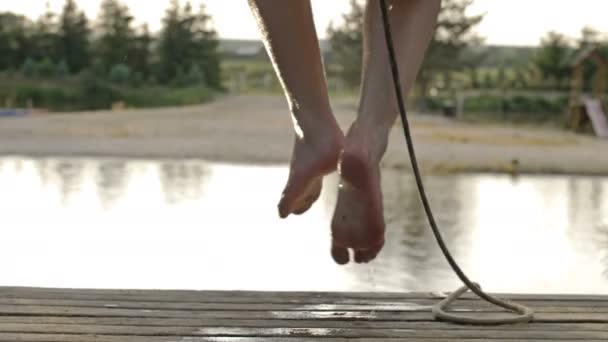 Teenager-Junge hat Spaß auf dem See. Er springt über den See und springt ins Wasser. Freude und Genuss der Sommerferien. — Stockvideo