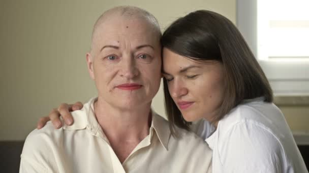Jovem abraça sua mãe doente após a quimioterapia. Amor, cuidado e apoio na família de um paciente oncológico. — Vídeo de Stock