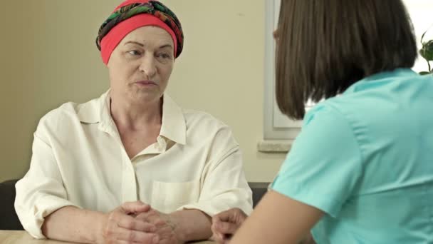 Pacjentka z rakiem nosząca chustę po chemioterapii konsultuje się z onkologiem. — Wideo stockowe