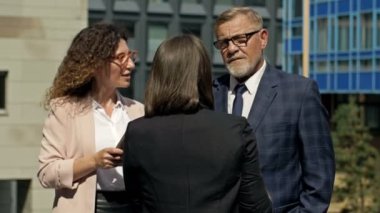 Ofis bahçesindeki iş ortaklarının iş konuşmaları. Firma çalışanları mola sırasında iletişim kuruyor.