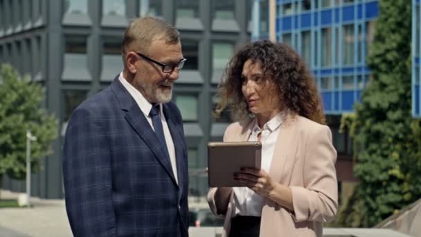 Business team man and woman working together outside. Boss and assistant holding tablet taking notes. Boss and secretary having consultation outdoor. — Stock Video