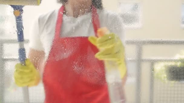 Trabajador de servicio de limpieza o ama de casa lava las ventanas con detergente y limpiaparabrisas. — Vídeos de Stock