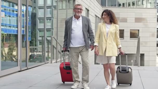 Ehepaar mit Koffern läuft durch Flughafen oder Bahnhof. — Stockvideo