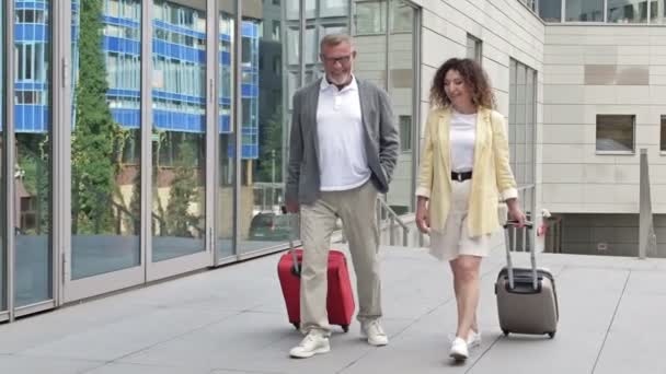 Getrouwd echtpaar met koffers die over het vliegveld of treinstation lopen. — Stockvideo