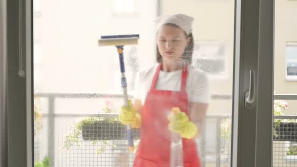 Aantrekkelijke vrouw wassen van het venster. Schoonmaak bedrijf werknemer werkt. — Stockvideo