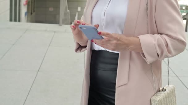 Elegante empresaria escribiendo una carta de texto en un teléfono móvil a través de Internet. — Vídeos de Stock