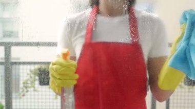 Sarı eldivenli, paçavra ve sprey deterjanla pencereyi temizleyen kadın elleri. Temizlik konsepti. Pencereleri spreyle siliyorum..