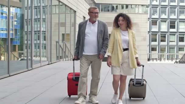 Ehepaar mit Koffern läuft durch Flughafen oder Bahnhof. — Stockvideo