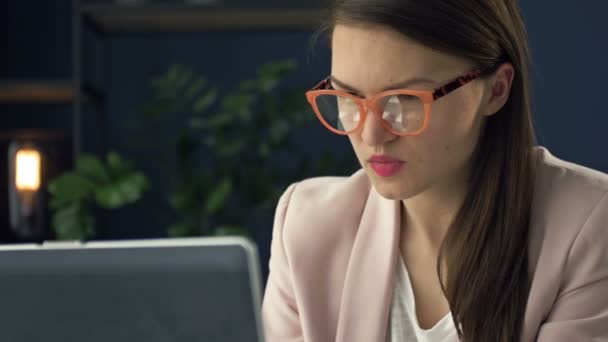 Portret van een vrouw van middelbare leeftijd die op een laptop werkt. Ze is geconcentreerd en attent.. — Stockvideo