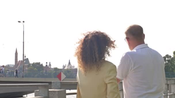 Vista traseira de um casal admirando a vista da cidade a partir da ponte. — Vídeo de Stock