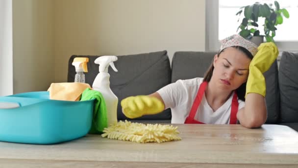 La jeune femme au foyer en a marre des devoirs. Femme surmenée entourée de produits de nettoyage se reposant du travail. Concept de travaux ménagers. — Video