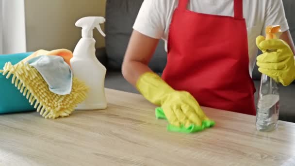 Frau in Schürze und Schutzhandschuhen wäscht und poliert die Arbeitsplatte gründlich. Anstrengende Arbeit. — Stockvideo