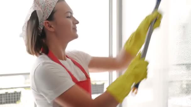 Piękna młoda gospodyni myje okna i tańczy. — Wideo stockowe