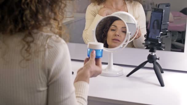 Alegre blogger femenina está mostrando productos cosméticos mientras graba video y da consejos para su blog de belleza. — Vídeos de Stock
