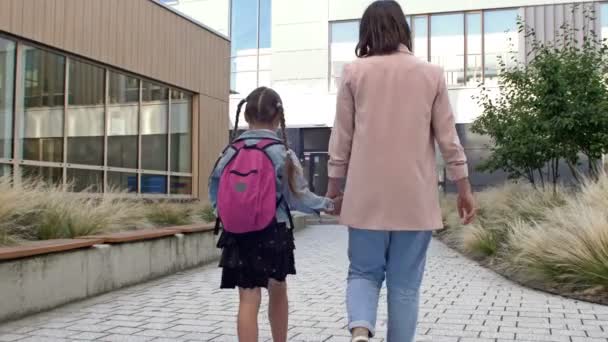 Κοριτσάκι με σχολική τσάντα ή τσάντα να πηγαίνει στο σχολείο με τη μητέρα του. Πίσω στο σχολείο.. — Αρχείο Βίντεο