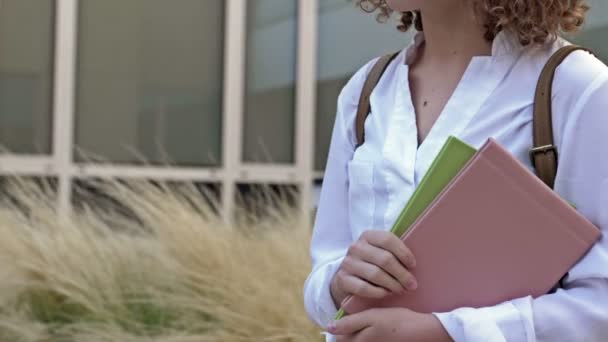 Estudante adolescente vai para a escola após as férias de verão, segurando livros e cadernos. De volta à escola. — Vídeo de Stock