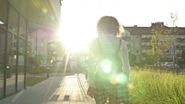 Tonårstjej, collegestudent eller high school-elev återvänder från lektionen. Bakifrån. — Stockvideo