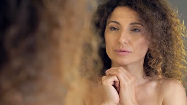 욕실 거울에 자신을 보고 있는 아름다운 중년 여성의 모습. — 비디오