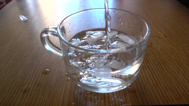 Налить воду в стакан со льдом — стоковое видео