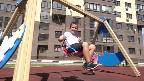 Niño feliz en un patio de recreo — Vídeo de stock