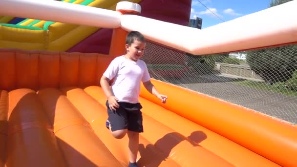 Niño feliz en un patio de recreo — Vídeos de Stock