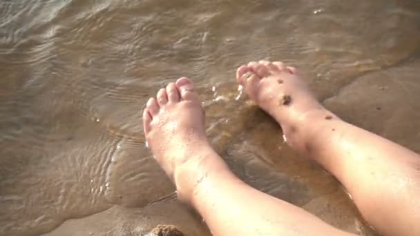 Close up slow motion kicking of a child splashing in the river — Stock Video