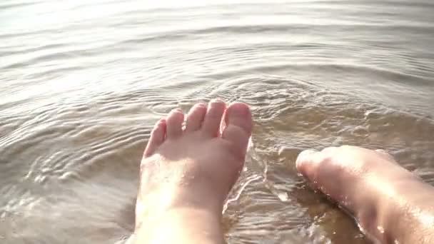 Primer plano patadas en cámara lenta de un niño salpicando en el río — Vídeos de Stock