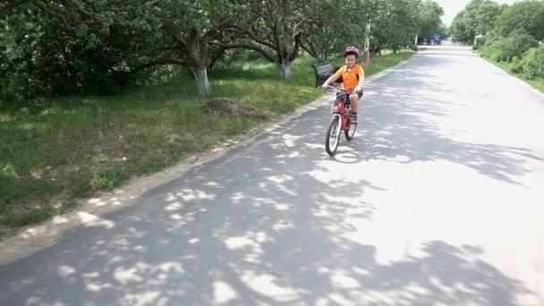Menino monta bicicleta em foco como ele se aproxima da câmera . — Vídeo de Stock