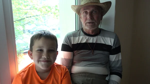 Avô e neto conversando, rindo e olhando para a câmera - o velho e a criança — Fotografia de Stock