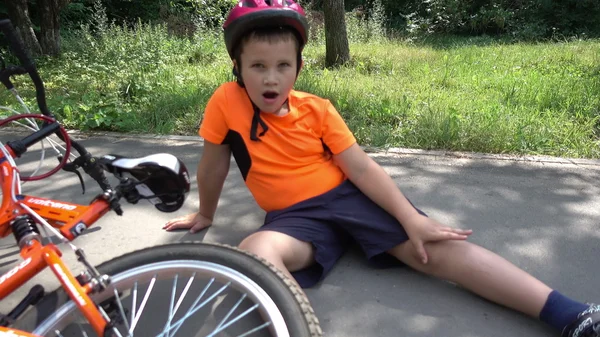 The boy fell off his bike, sitting on the ground — Stock Photo, Image