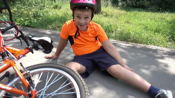 The boy fell off his bike, sitting on the ground — Stock Photo, Image