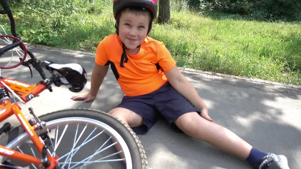 The boy fell off his bike, sitting on the ground — Stock Photo, Image