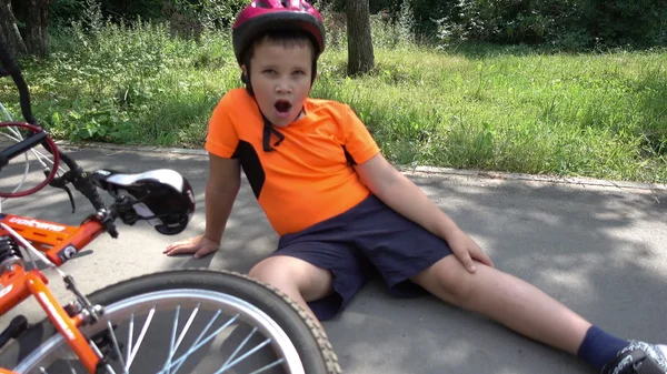 The boy fell off his bike, sitting on the ground — Stock Photo, Image