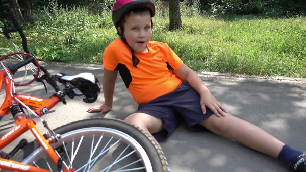The boy fell off his bike, sitting on the ground — Stock Photo, Image