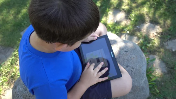 Menino com um tablet na natureza — Fotografia de Stock