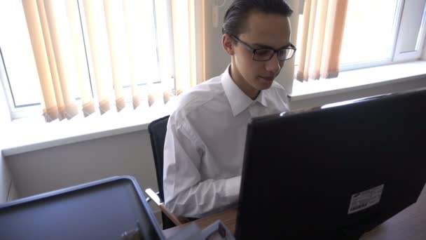 Den unge mannen arbetar på dator i office — Stockvideo