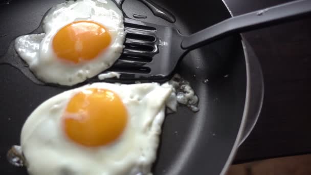 Готовить яичницу на раскаленной сковороде — стоковое видео