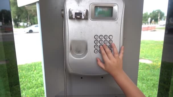 Ankesörlü telefon. Bir çocuk elini açık bir Ankesörlü telefon alarak Close-Up — Stok video