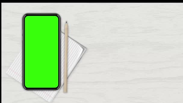 Beyaz ahşap bir tezgaha karşı üst manzaralı boş yeşil ekranlı akıllı telefon. 4K animasyon, tasarım ekranındaki sunum için hareketleri izler. 3 Boyutlu Hazırlama — Stok video