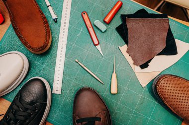 Ayakkabı yapımı aletler. Cetvel, tül, bıçak, boya ve deri, ayakkabı. Yeşil arkaplan üst görünüm kopyalama alanı