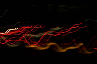 Dijital ışıkların hızı. Parlak kırmızı ve beyaz neon bir yörünge boyunca hızla hareket eden ışık akışları. Flaşlı hızlı enerji dalgaları. Siyah arkaplanda girdap izi.