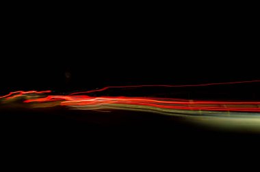 Dijital ışıkların hızı. Parlak kırmızı ve beyaz neon bir yörünge boyunca hızla hareket eden ışık akışları. Flaşlı hızlı enerji dalgaları. Siyah arkaplanda girdap izi.